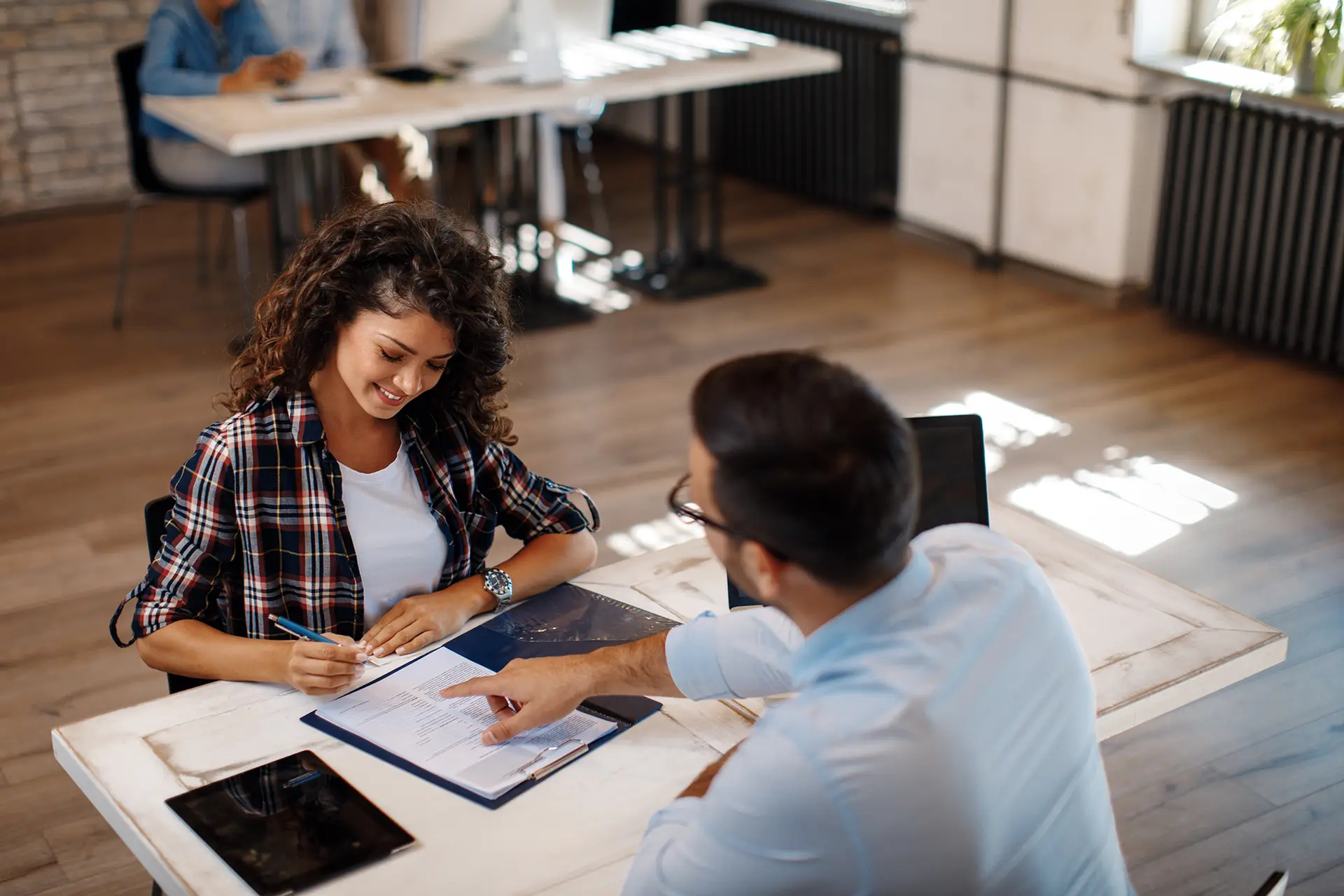 Young woman signing contract with manager Young woman signing contract with manager